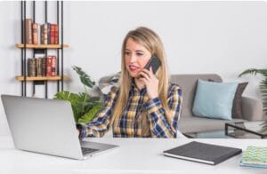 Business professionals using laptop and phone for AI customer support interaction.